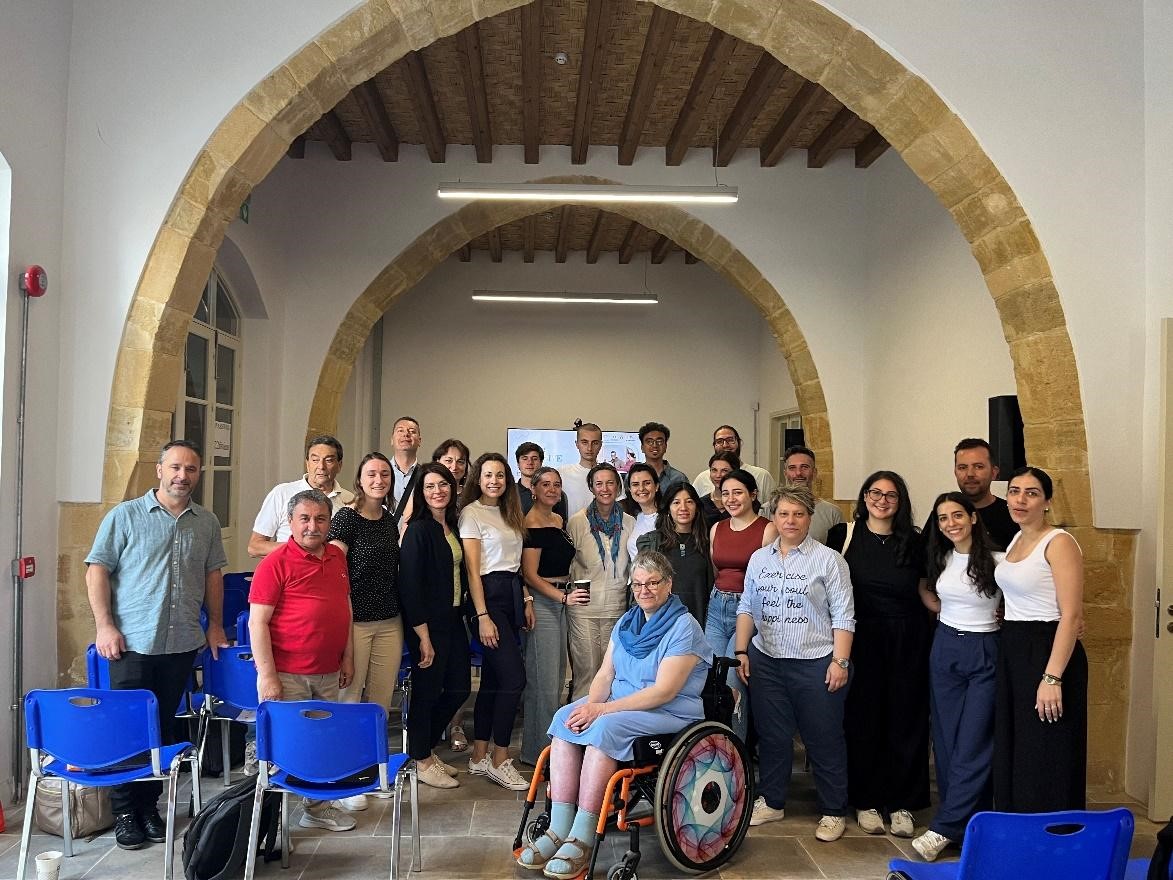 Photo shows all participants together in a group photo standing and smiling